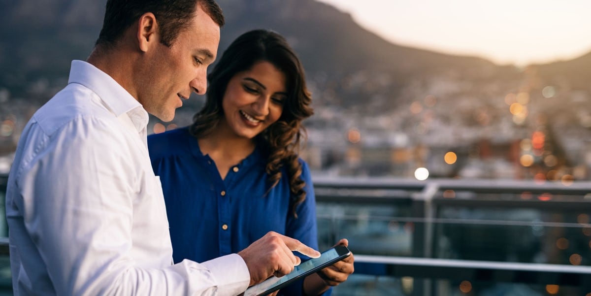 two professionals outdoors looking at phone