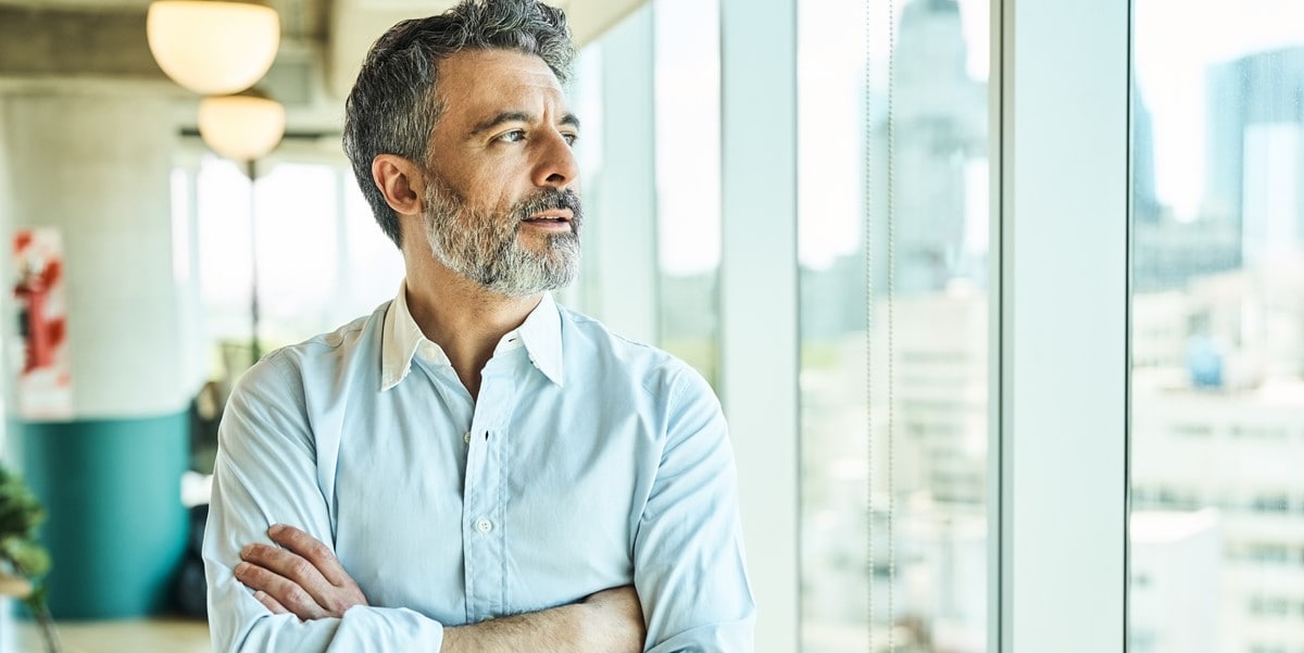 professional man in office, looking out window