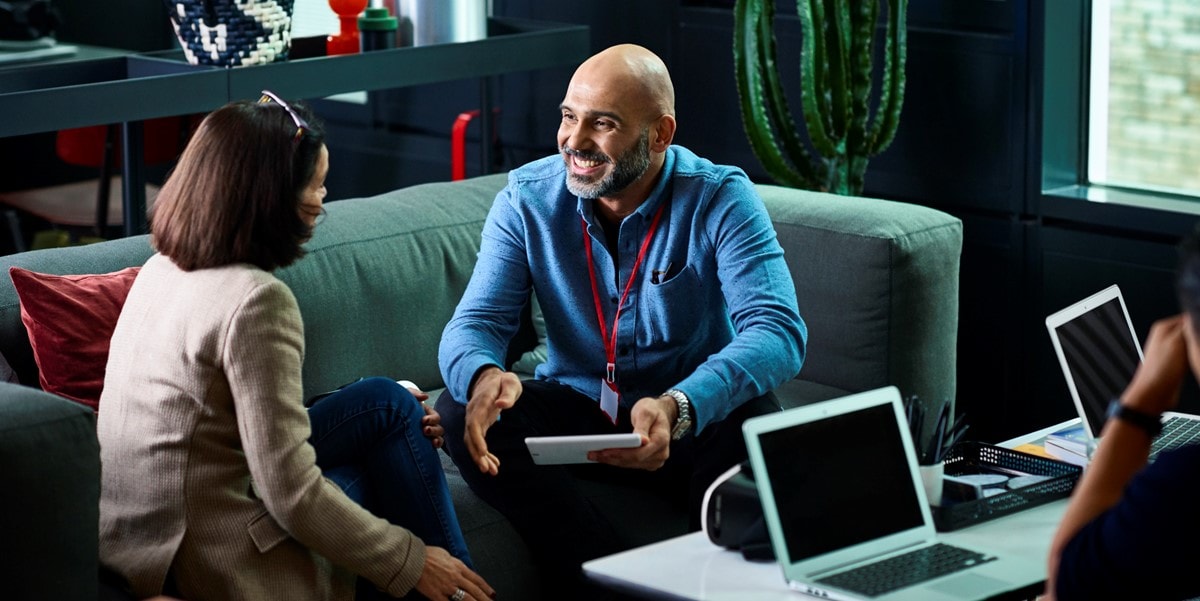 two people in office sitting on couch talking