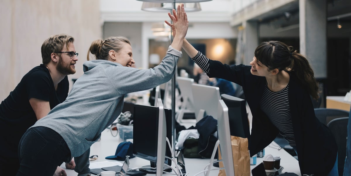 coworkers high-five over computer