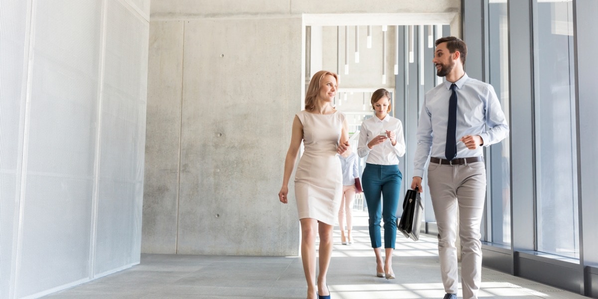 business professionals talking while walking in office