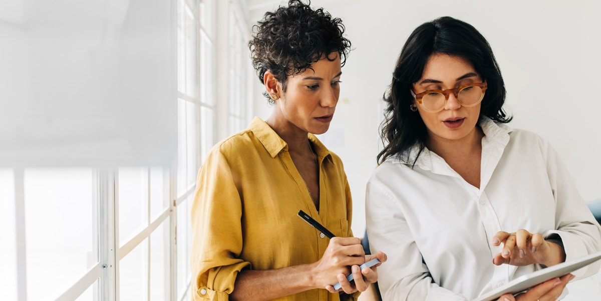 two professional women in office looking at document