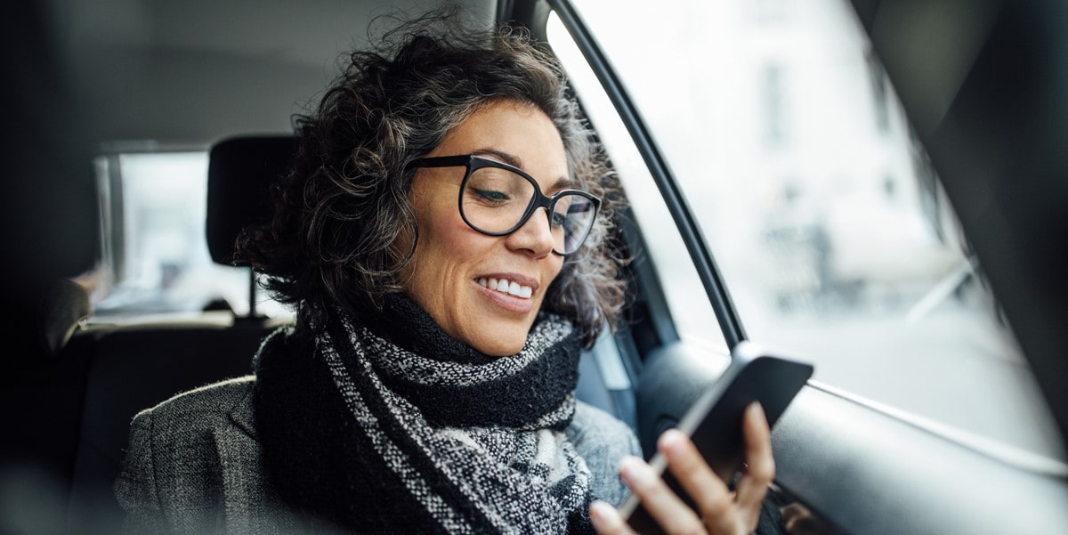 woman in car holding phone