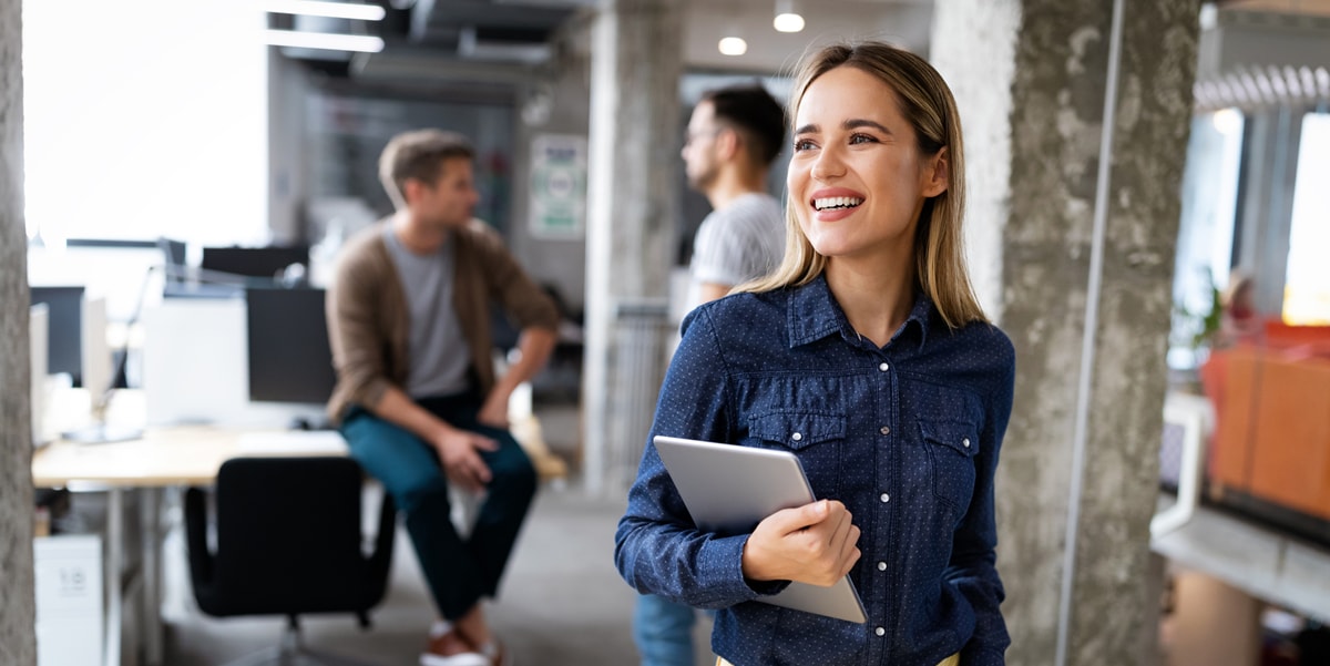 woman in office with laptop in arm