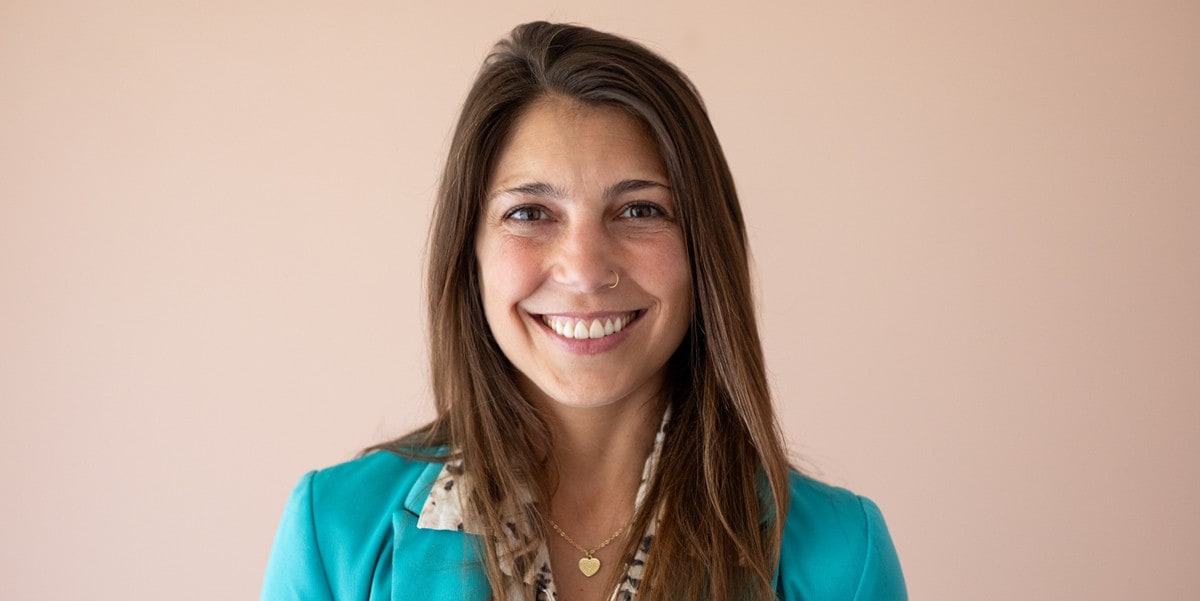professional woman smiling, wearing a green blazer