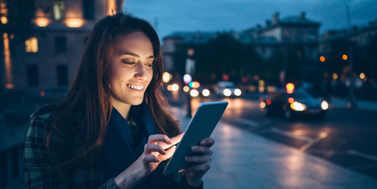 woman using cell phone, outside, city at night