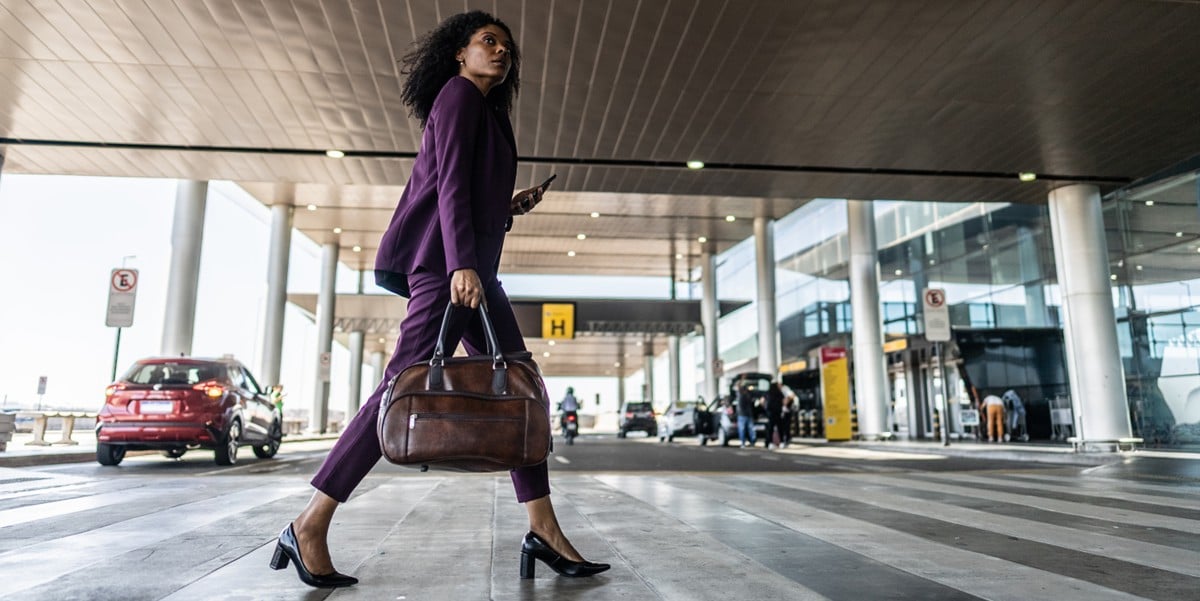 woman with bag walking into building