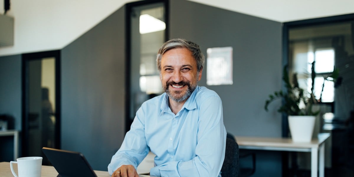 smiling man seated at desk in the office