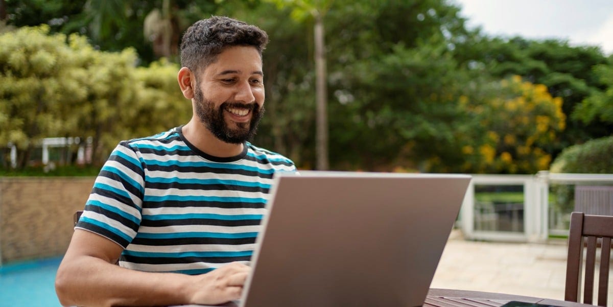 man working outside, using laptop