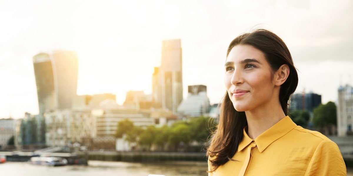 woman smiling, standing outside, in front of city skyline