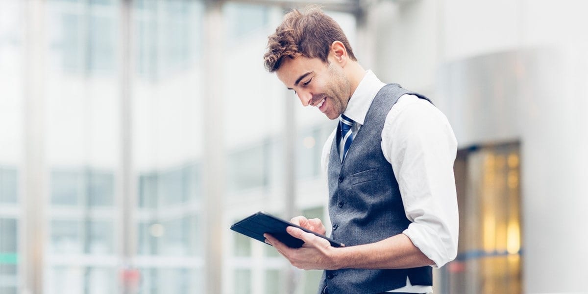 man in suit looking down at tablet