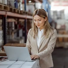 woman using laptop in warehouse