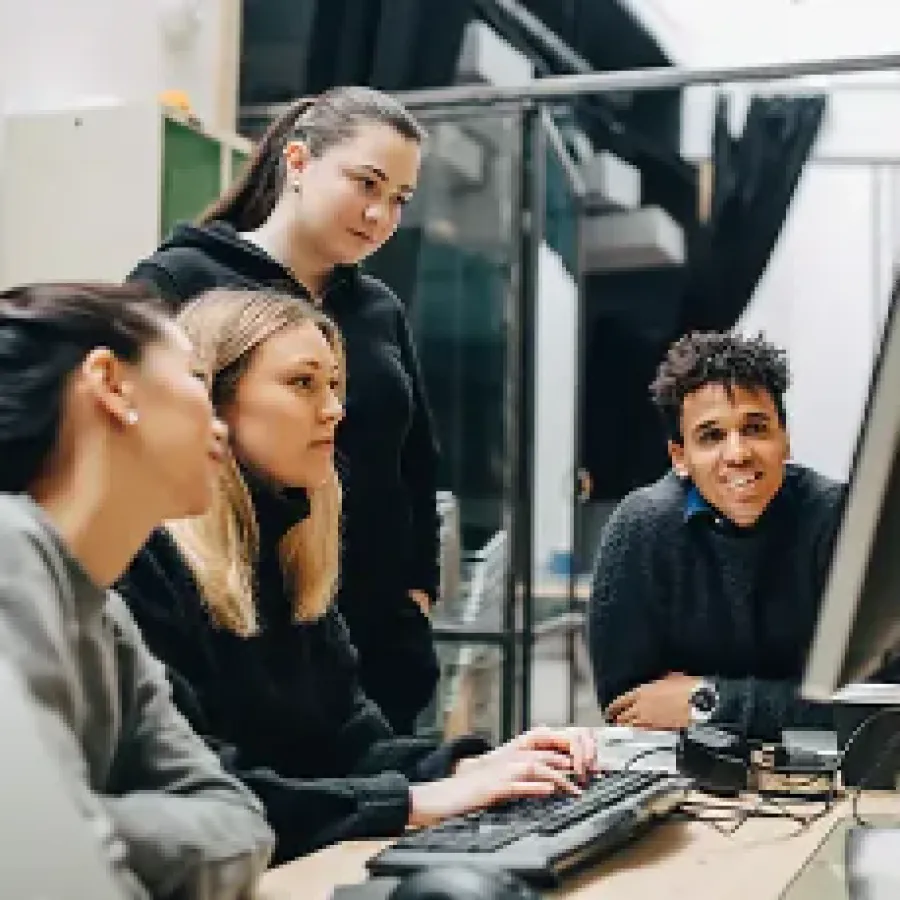 people working around a desktop computer